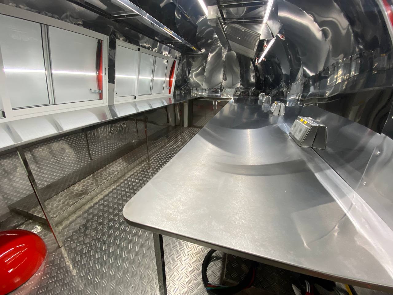 Stainless service counter and open windows inside the red MobiAir trailer