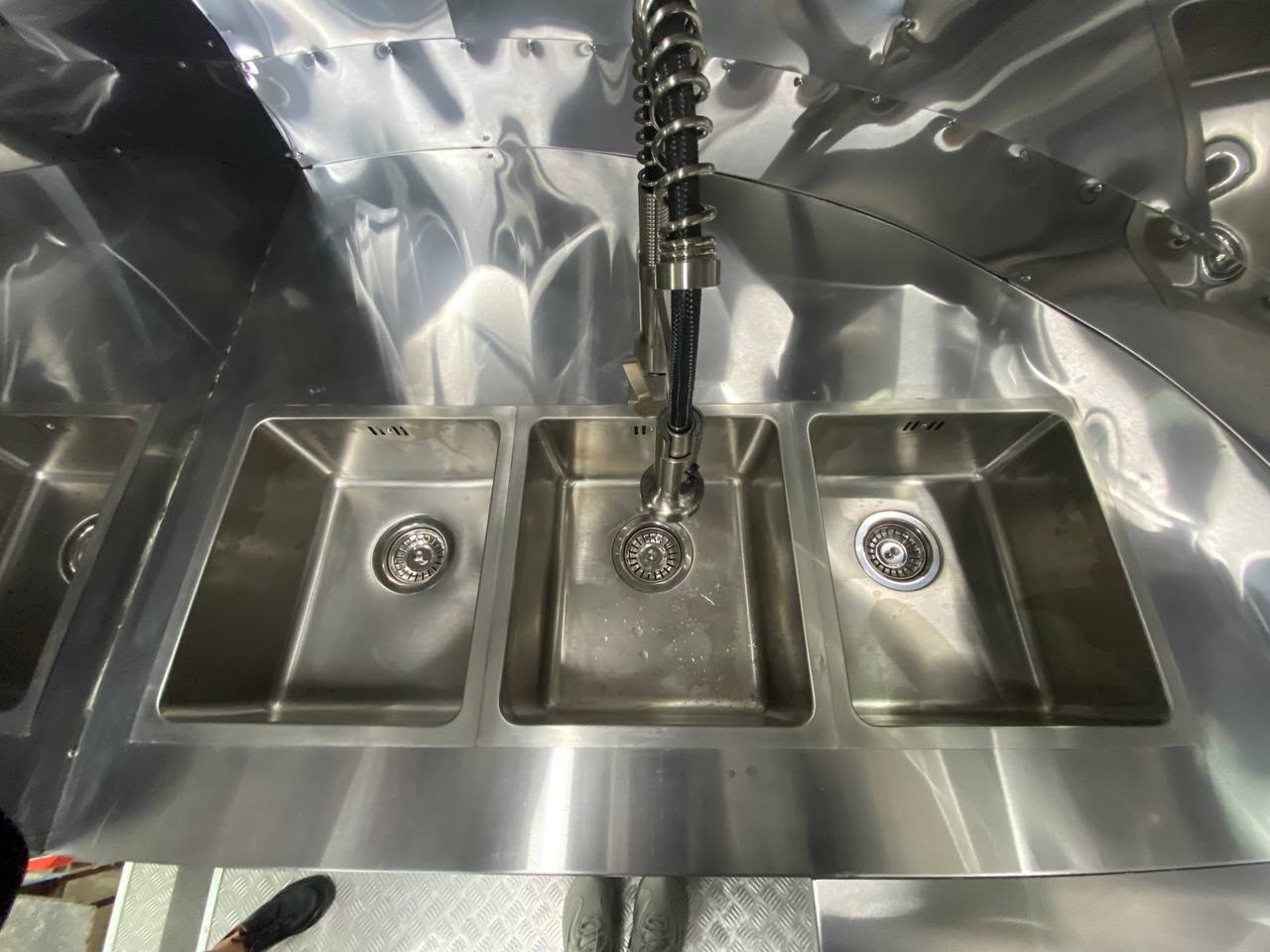 Three-basin stainless sink inside the completed red MobiAir trailer