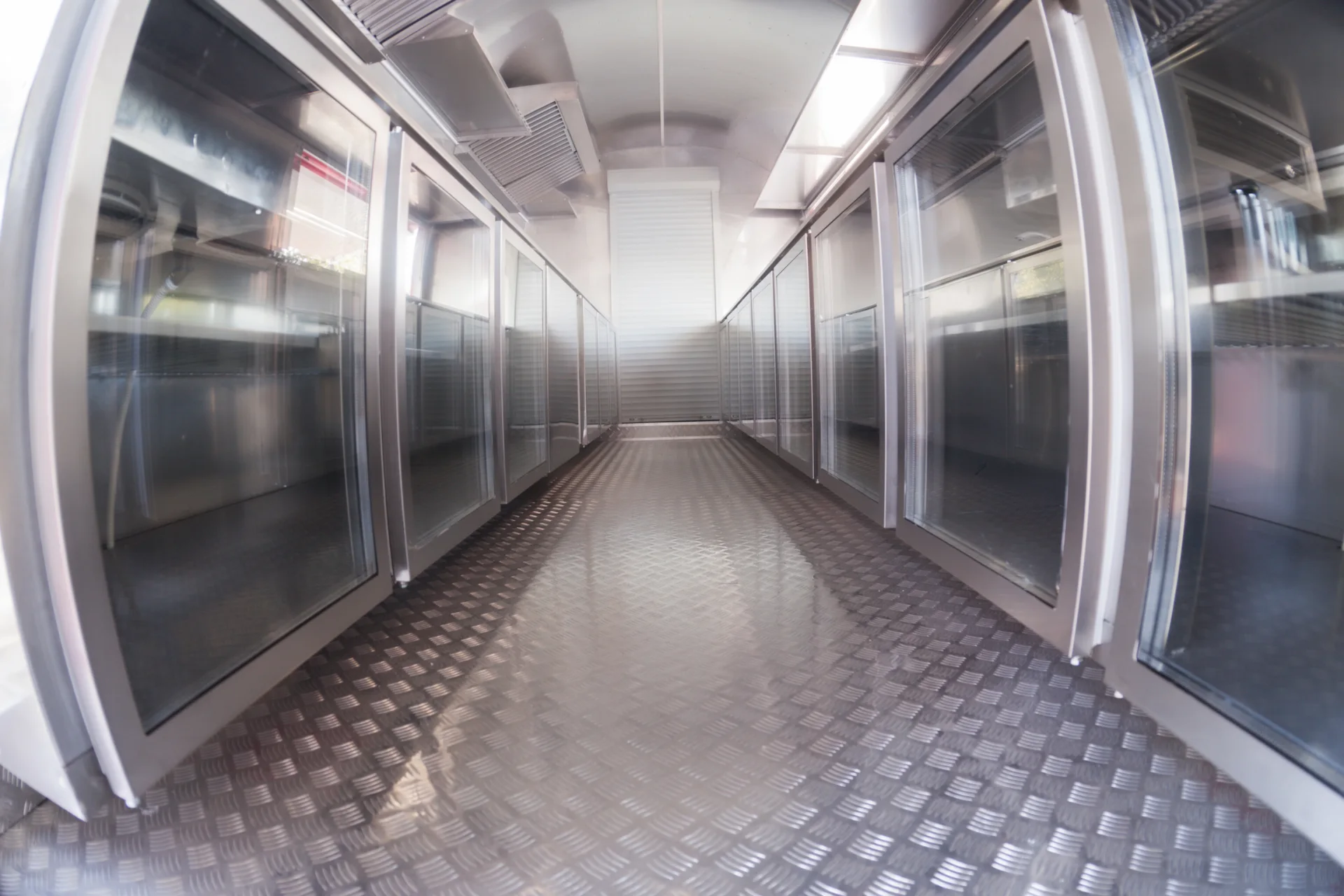 Open MobiEdge 8 interior with glass-front storage cabinets and diamond-plate floor