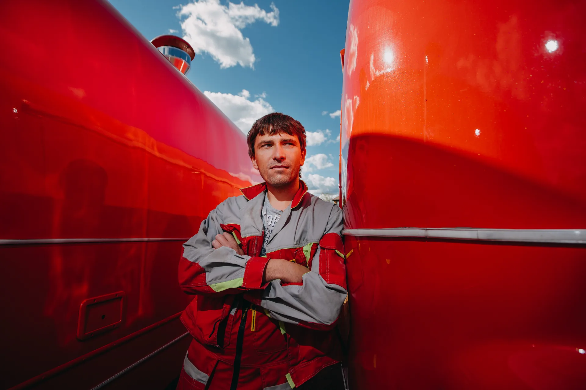 MOBITRUCK production worker standing between two red mobile trailer shells