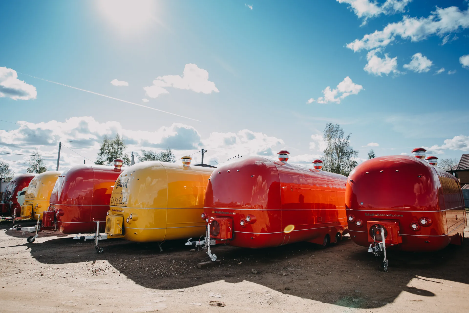 Colorful rounded MOBITRUCK trailer shells lined up outside the factory