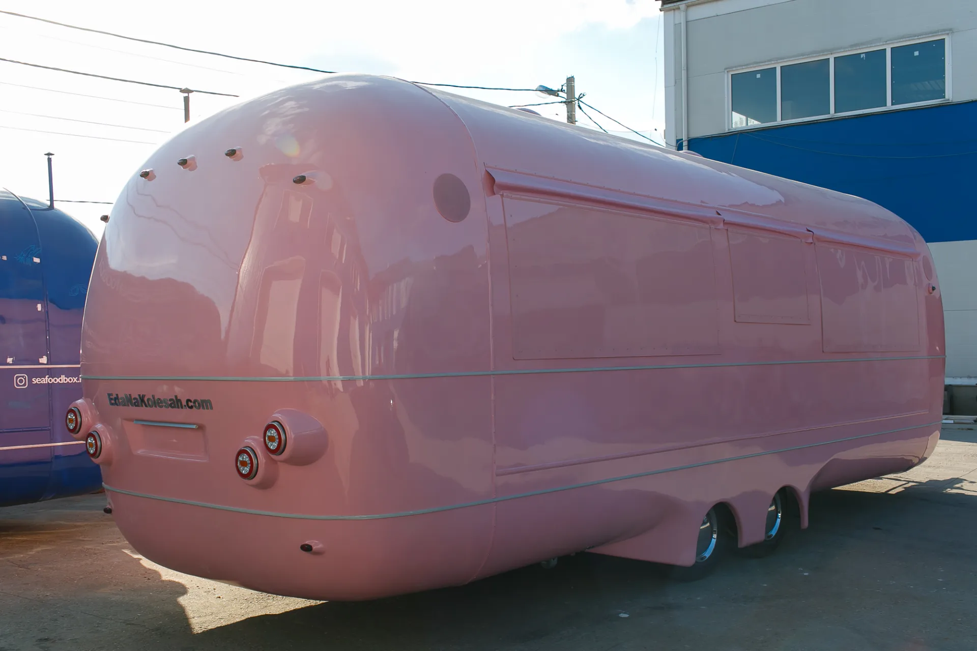 Pink MobiEdge 8VT trailer shell viewed from the rear quarter with service hatches closed