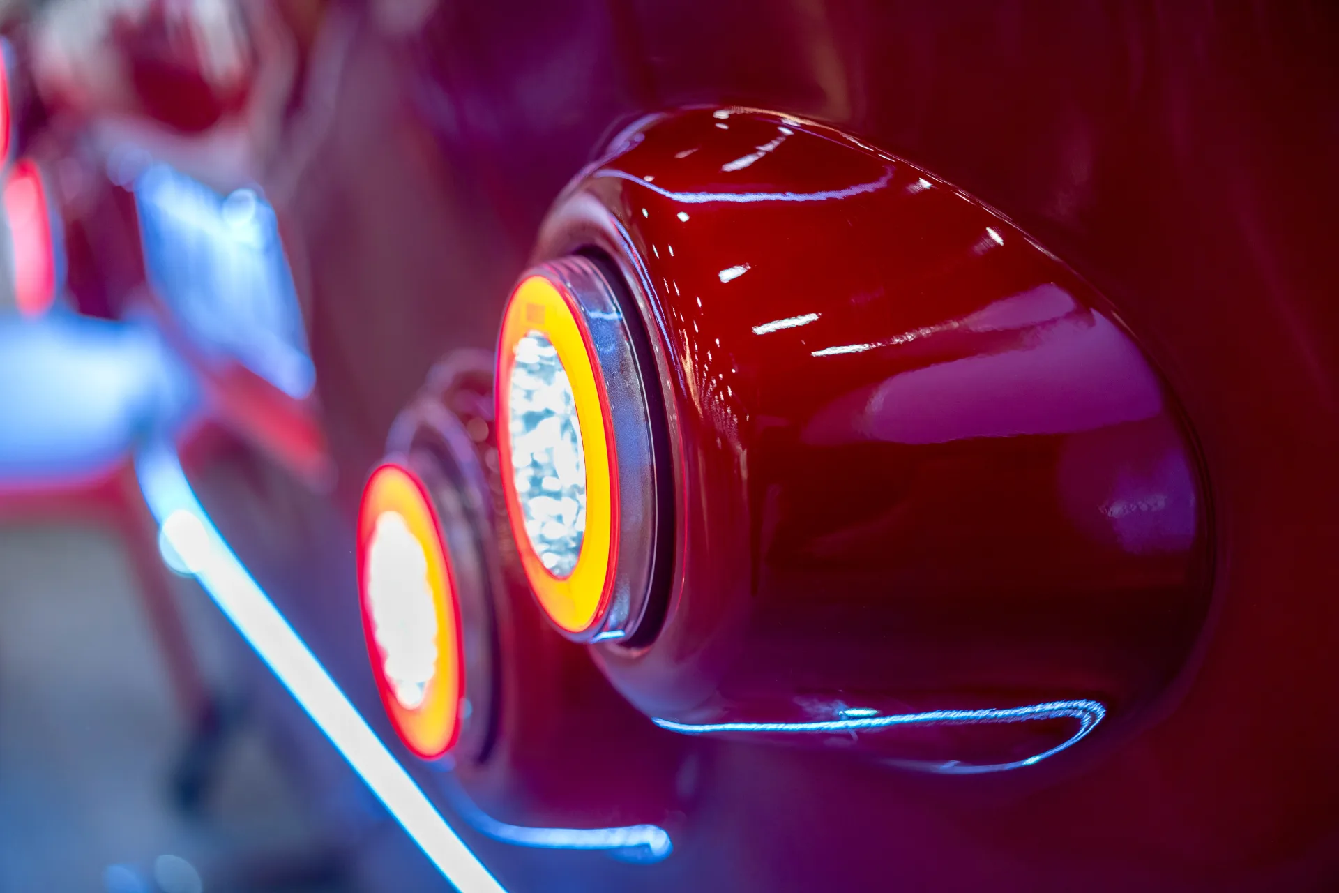 Close view of illuminated round rear lights and accent lighting on a red mobile trailer