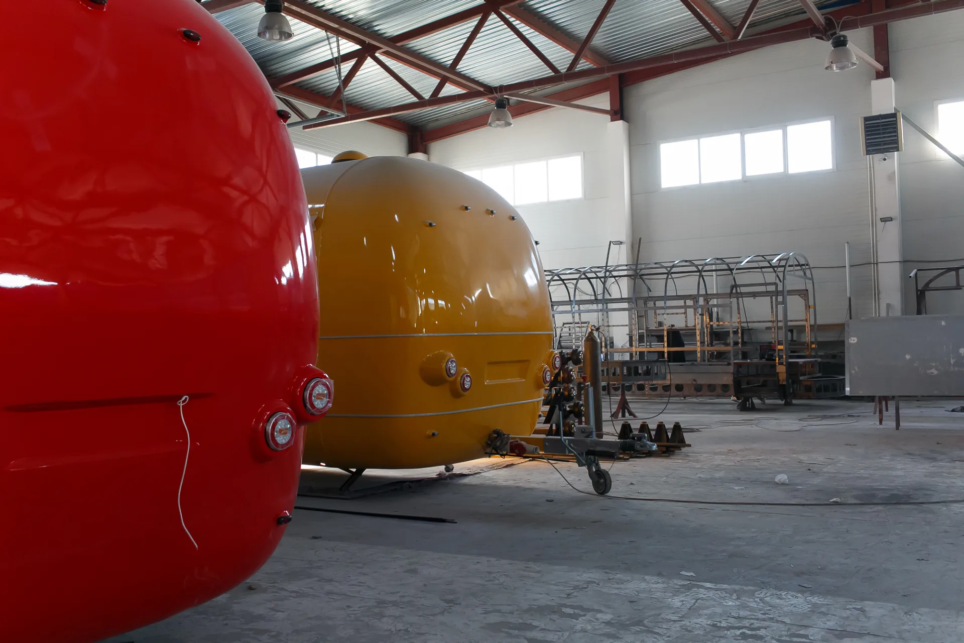 Red and yellow rounded mobile trailer shells during production inside the MOBITRUCK factory