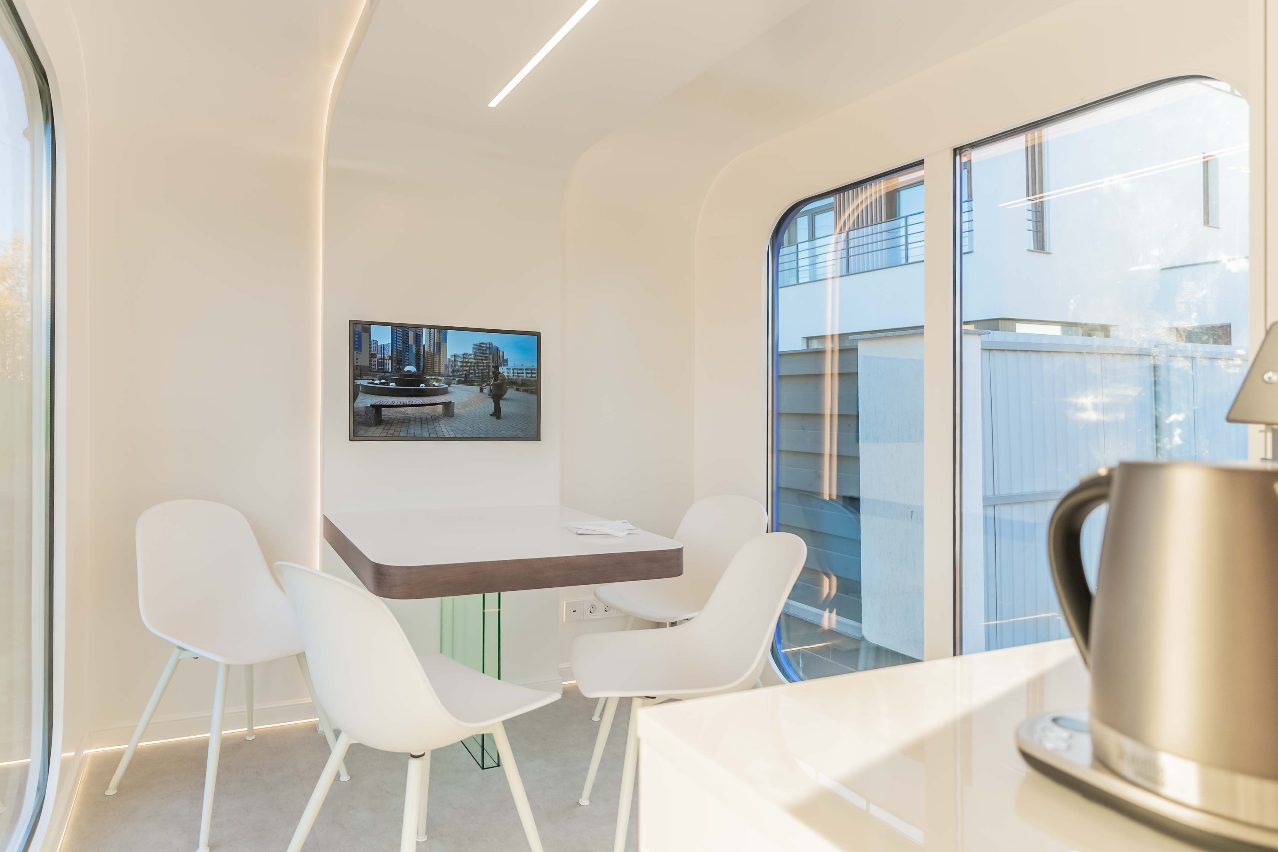 MT-8 mobile showroom interior with a wall-mounted display, meeting table, seating, lighting and visible receptacles