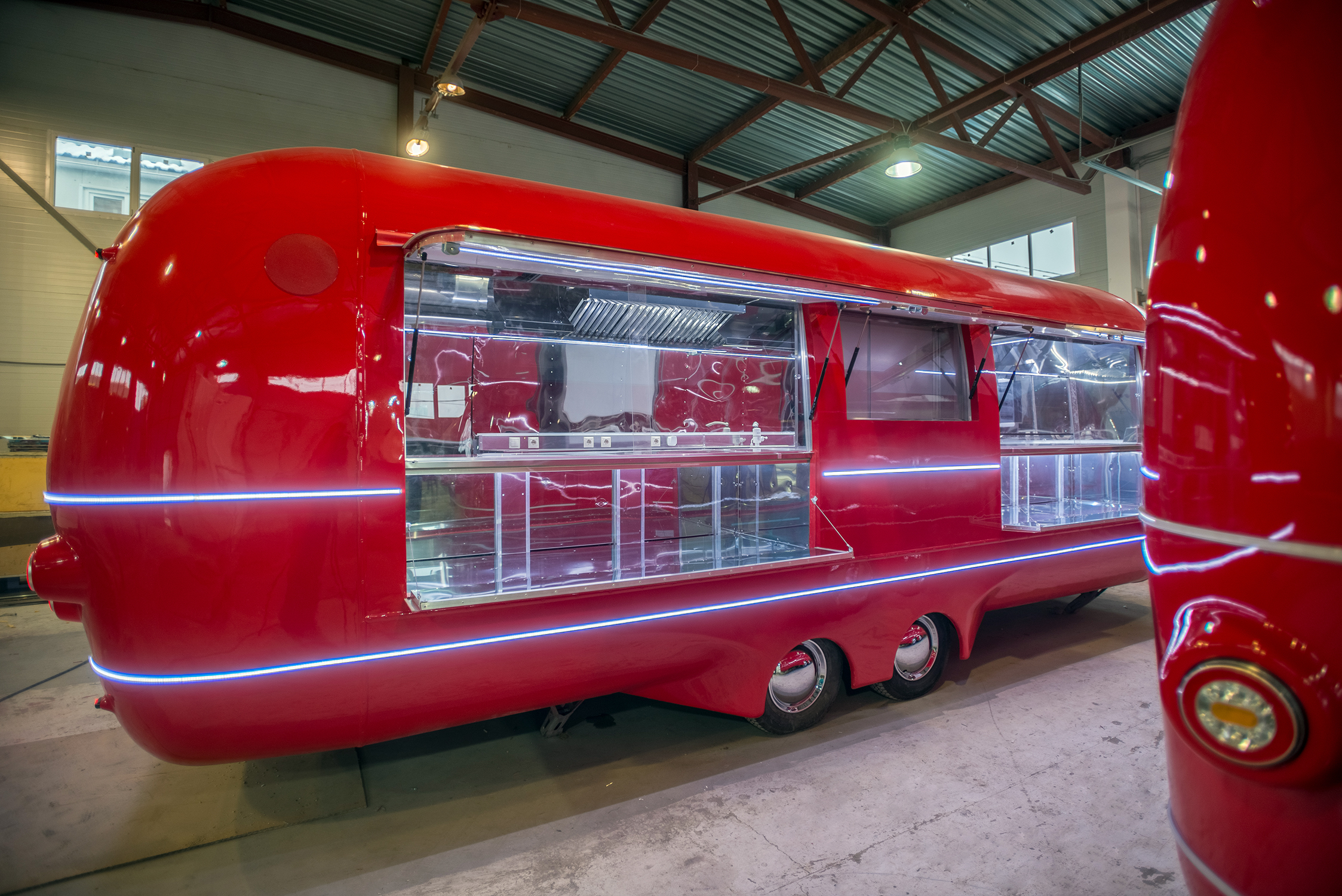 Red MOBITRUCK commercial trailer platform with open service windows inside the production facility