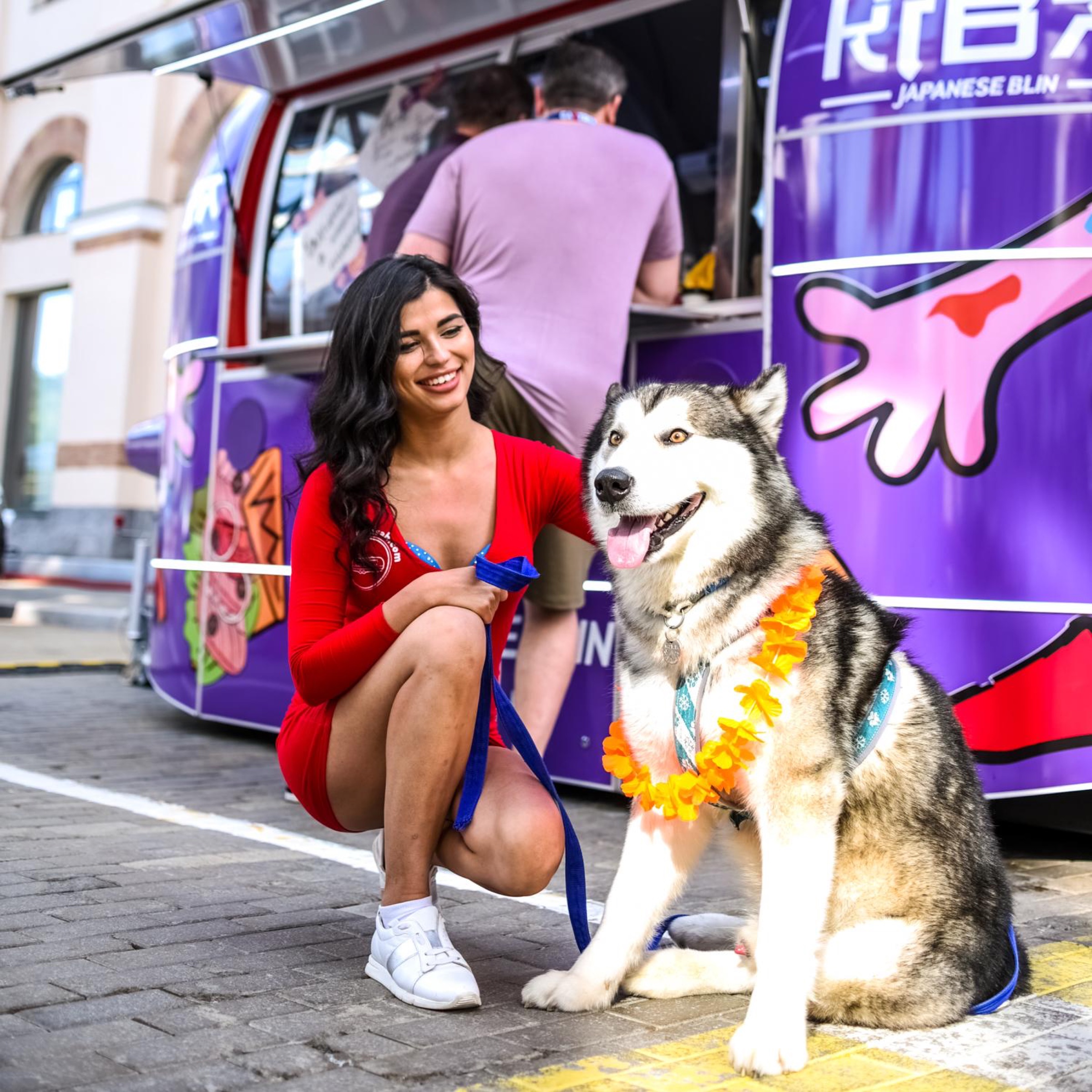 Full view of a guest and husky beside the operating KIBA food trailer