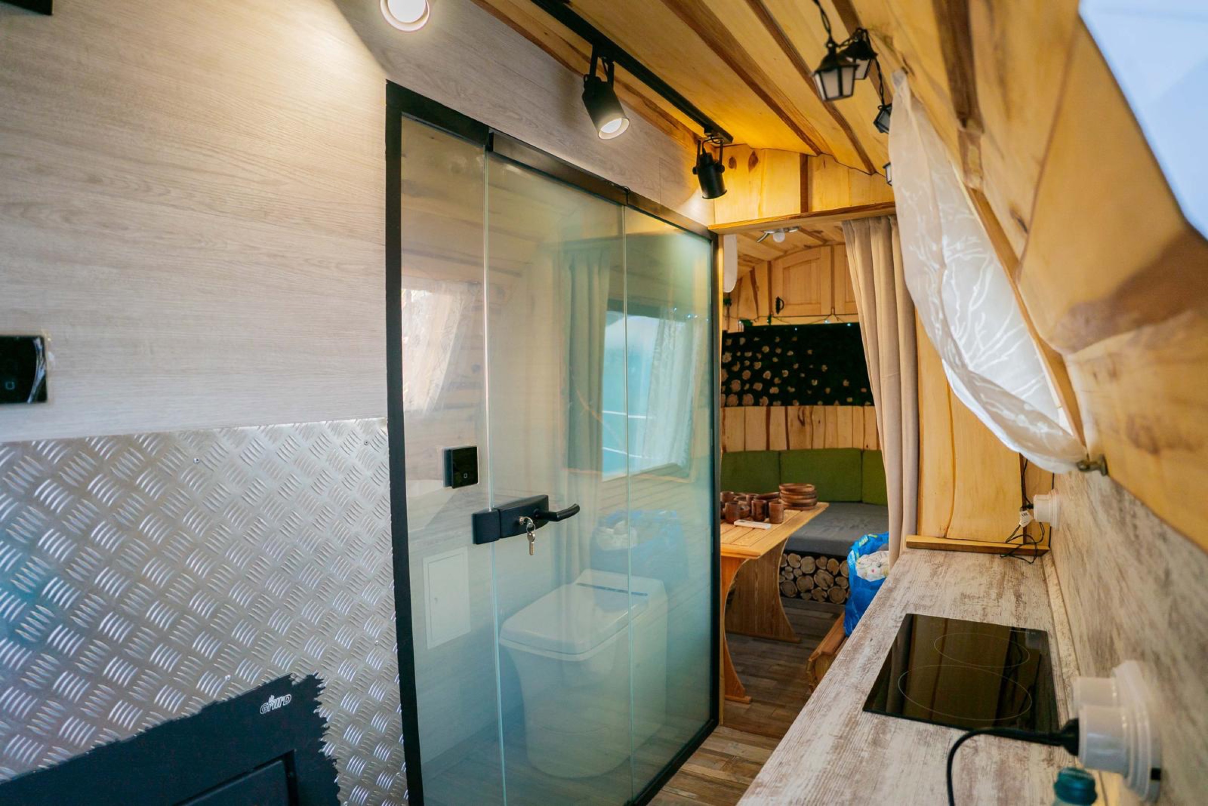Interior view through the MobiSauna wash area toward the wood-lined guest lounge