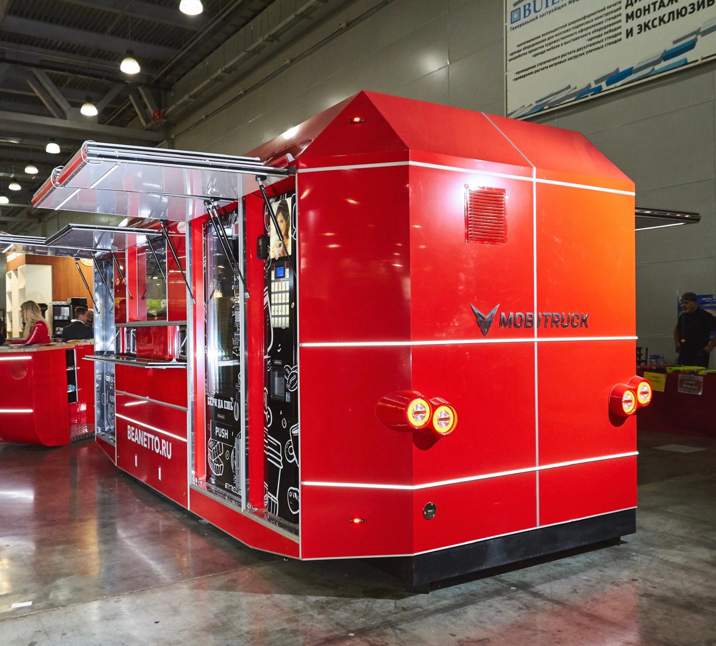 Wide rear three-quarter view of the red MobiVending unit with its awnings open